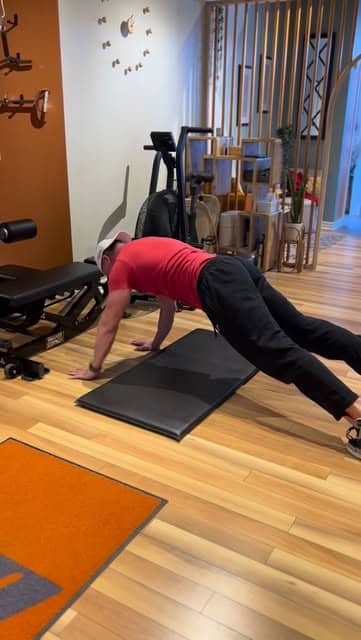 A member stretching on a mat on the Bar None studio floor