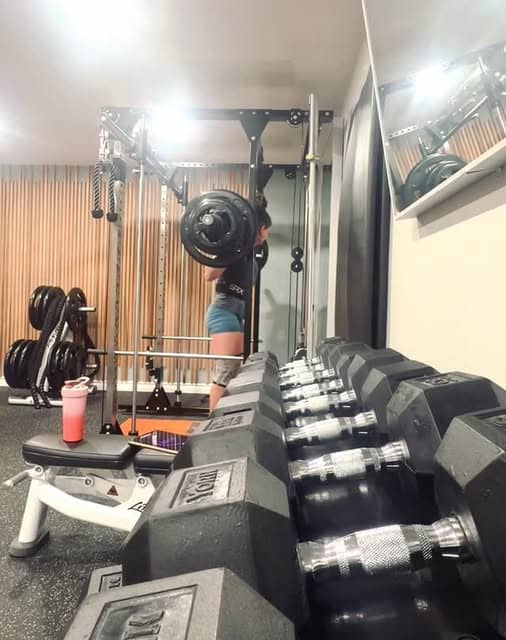Dumbbell rack and squat rack inside the Bar None training floor